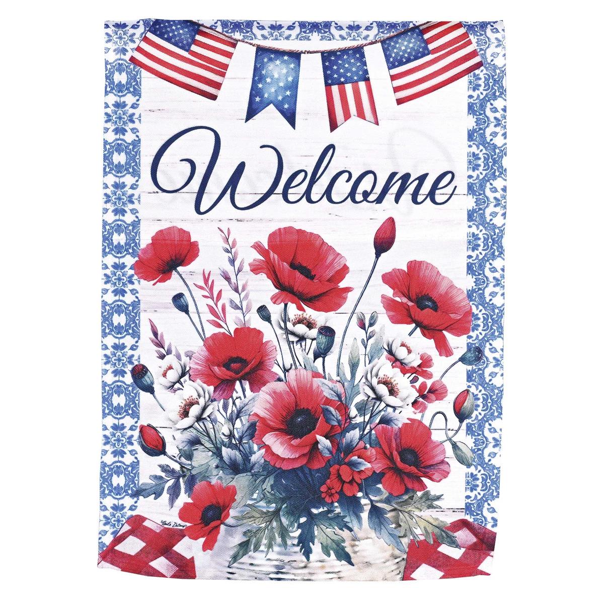 13x18 printed garden flag with patriotic style: red poppies surrounding the word Welcome, mounted on a yard stand in a landscaped garden.