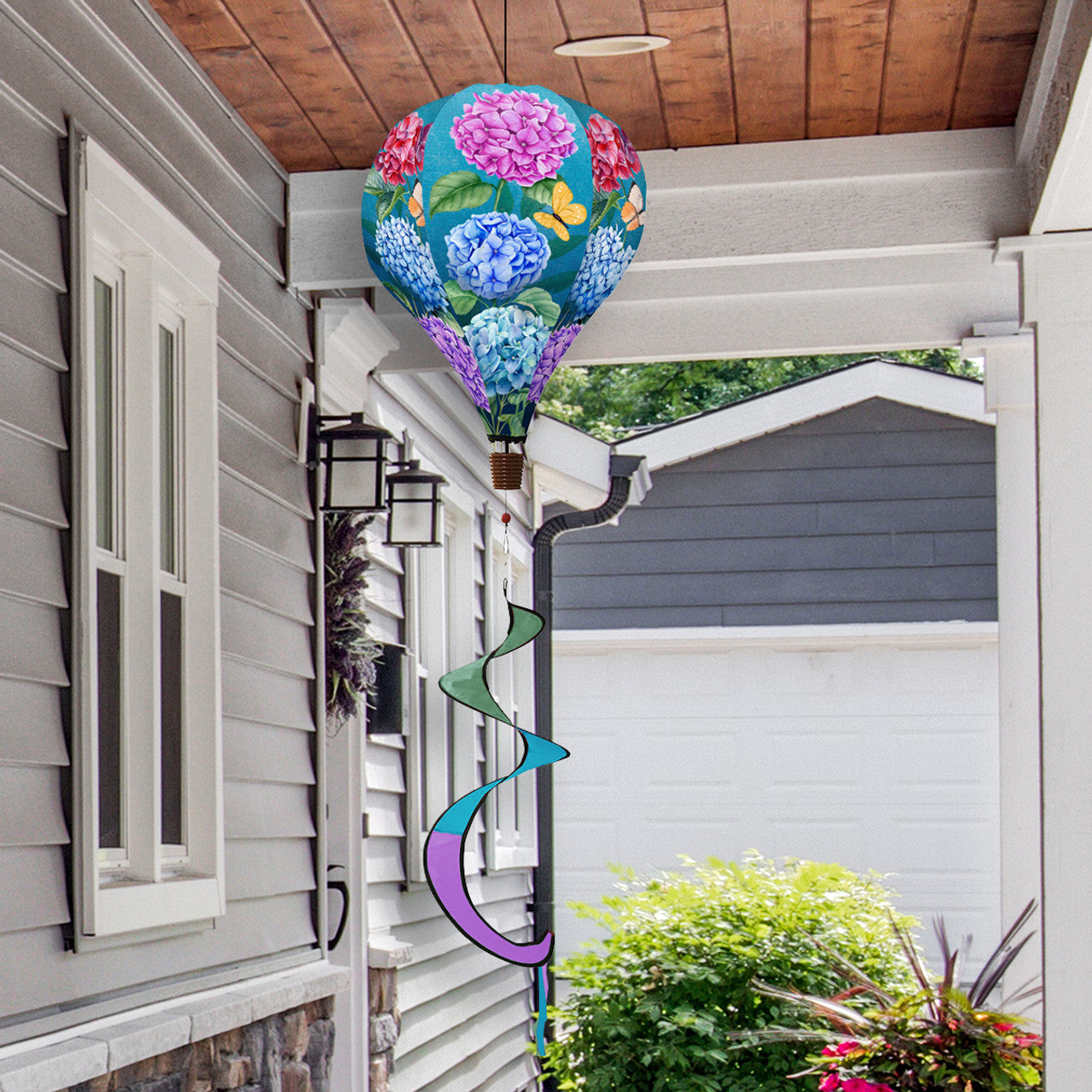 Hot air balloon spinner with watercolor hydrangeas, durable polyester fabric, and breezy motion for charming spring and summer outdoor floral décor.
