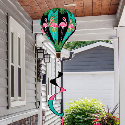 Hot air balloon spinner with pink flamingos and tropical greenery, made of weather-resistant polyester for colorful, breezy outdoor summer garden décor.