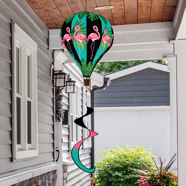 Hot air balloon spinner with pink flamingos and tropical greenery, made of weather-resistant polyester for colorful, breezy outdoor summer garden décor.