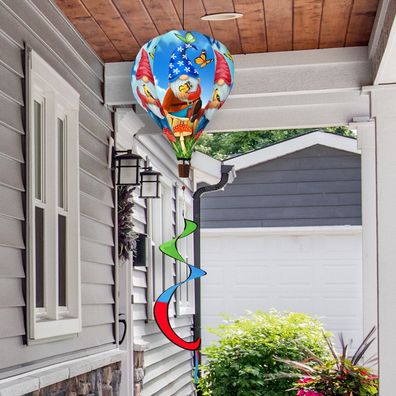 Hot air balloon spinner with garden gnome, vibrant florals, and weather-resistant polyester for fun, breezy outdoor seasonal or year-round decoration.