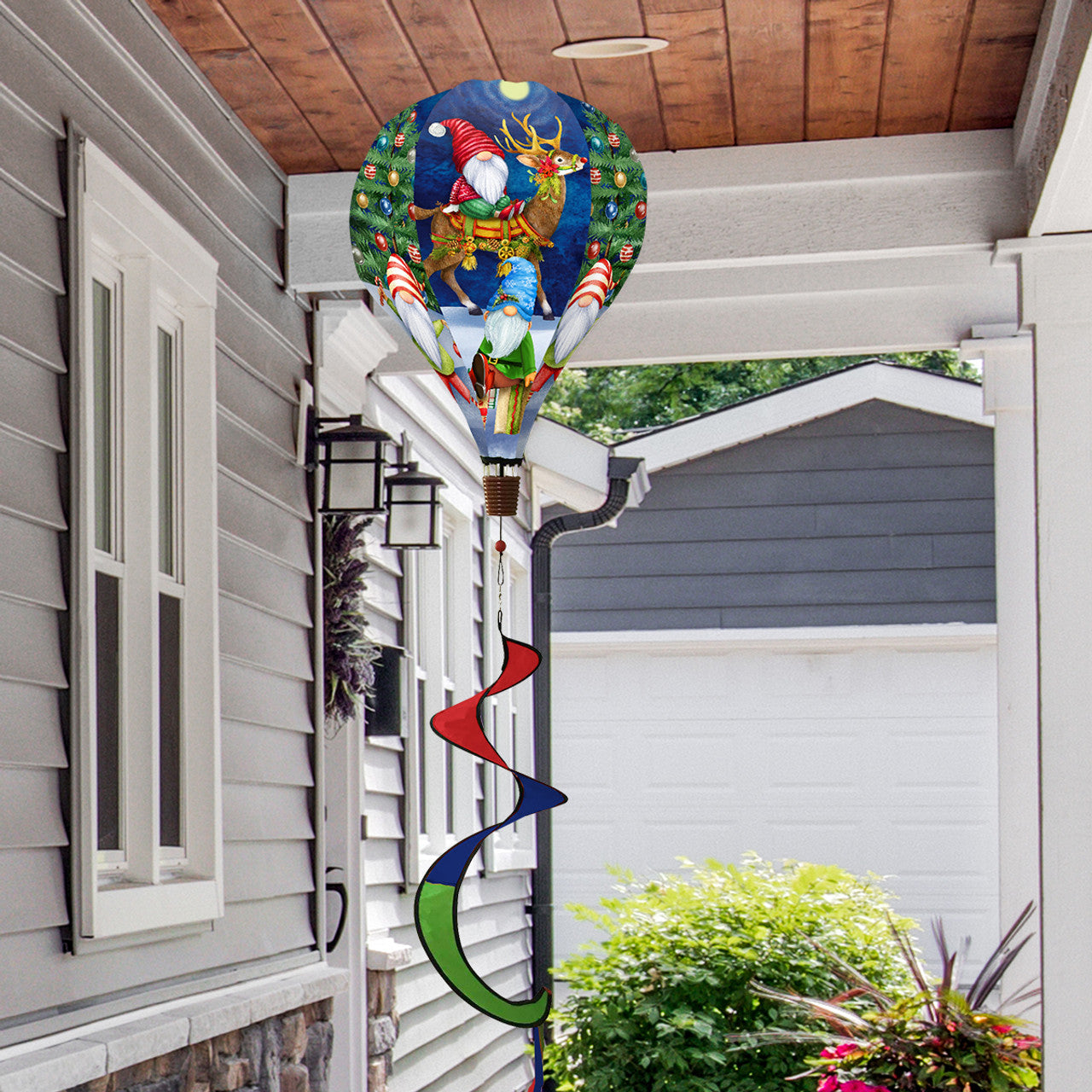 Hot air balloon spinner with festive gnomes, holiday accents, and weather-resistant polyester for colorful, joyful Christmas outdoor garden décor.