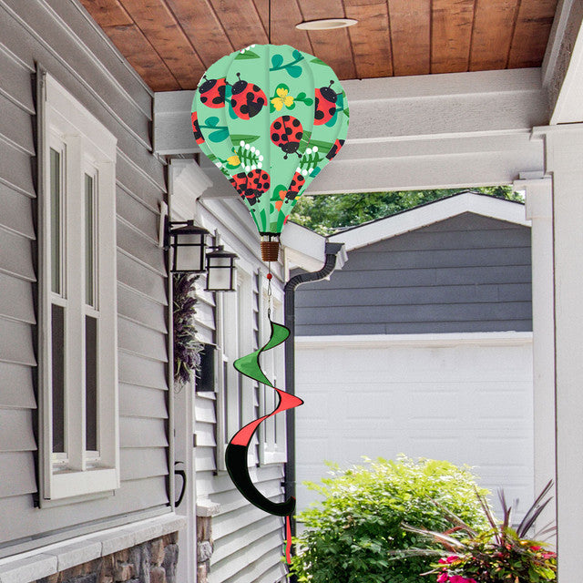 Hot air balloon spinner with bright red ladybugs and florals, made of weather-resistant polyester for fun, breezy spring and summer garden décor.
