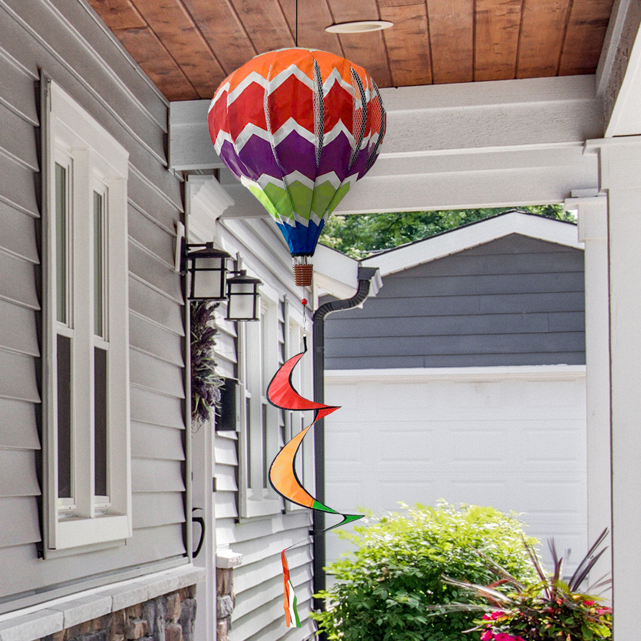 Hot air balloon spinner with rainbow panels and breezy motion, crafted from weather-resistant polyester for bold, colorful outdoor garden or patio décor.