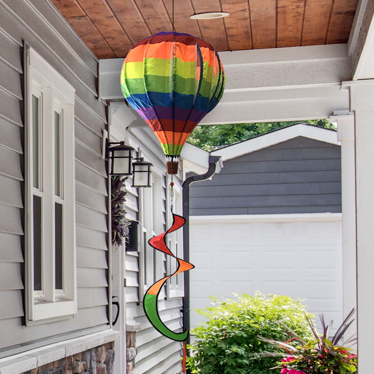 Colorful rainbow hot air balloon spinner with weather-resistant polyester and swirling motion, perfect for brightening up gardens, porches, and patios.