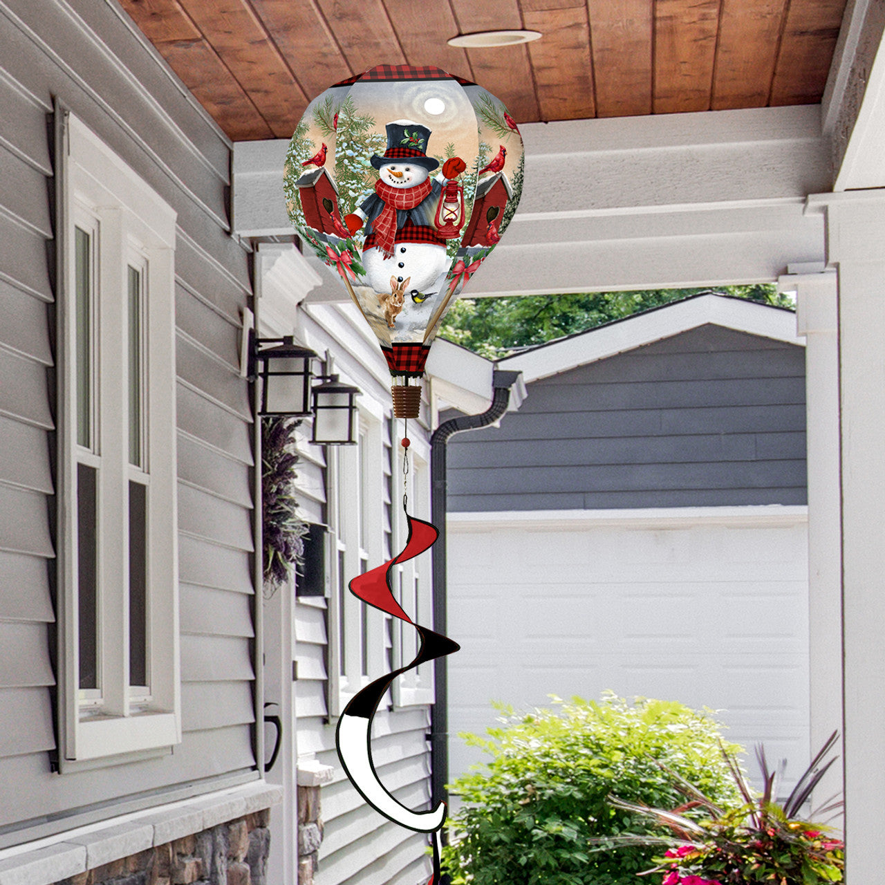 Hot air balloon spinner with smiling snowman and forest animals, crafted from weather-resistant polyester for festive, breezy winter outdoor garden décor.