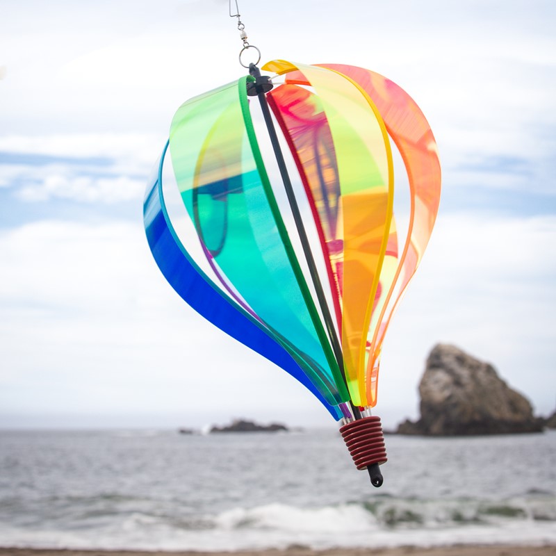 Iridescent Rainbow 6-Panel Hot Air Balloon soaring outdoors, showcasing its vibrant, shimmering rainbow hues against a bright, open sky.