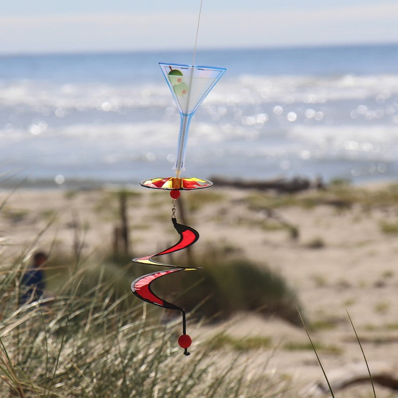Mini Martini 5 O’Clock Drink Spinner spinning outdoors, highlighting its lively martini-themed design against a breezy, bright sky.