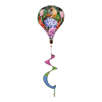 Hot air balloon spinner with vibrant red cardinals and wintry background, crafted from weather-resistant polyester for graceful outdoor seasonal decoration.