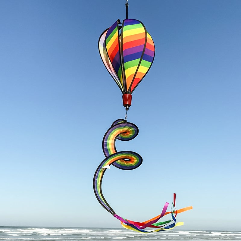 Rainbow Swirl 6-Panel Hot Air Balloon soaring outdoors, showcasing its dazzling, colorful swirl design against a bright, open sky.
