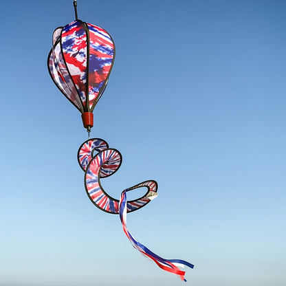 Red, White, and Blue Tie Dye 6-Panel Hot Air Balloon soaring outdoors, showcasing its bold tie-dye pattern against a clear, open sky.